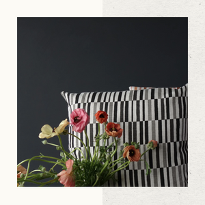 Beautiful flower and pillows on a dark background, this image features the Cloth Edition accent throw pillow with block print design